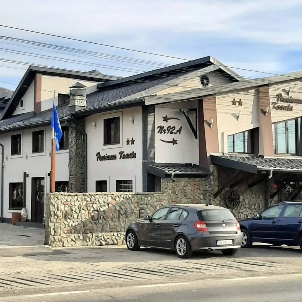 Pensiunea Kometa văzută de pe DN7, ziua, cu parcarea din față