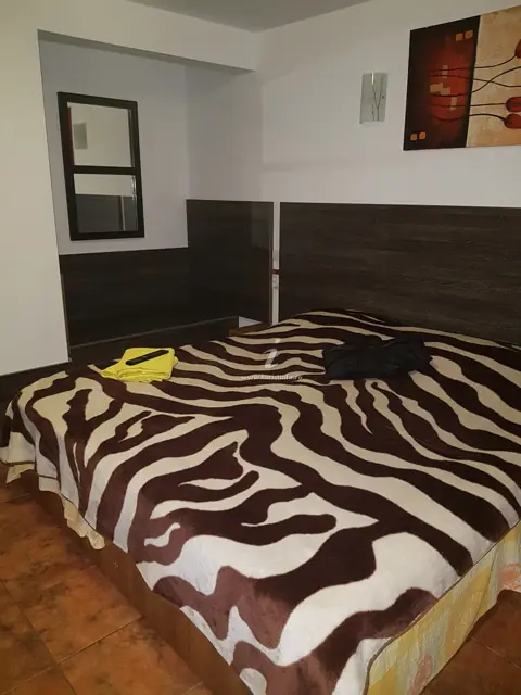 Cameră cu pat dublu și cuvertură cu dungi