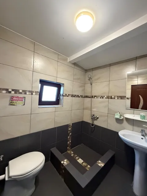 Baie cu duș zidit și faianță bej