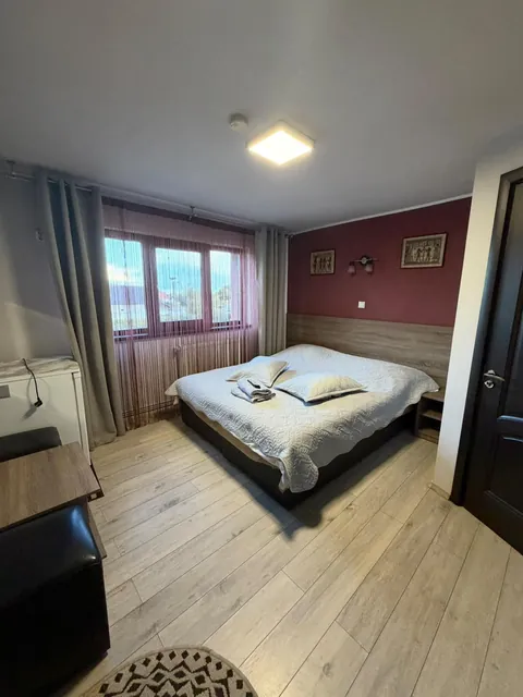 Cameră cu perete vișiniu și ferestre mari