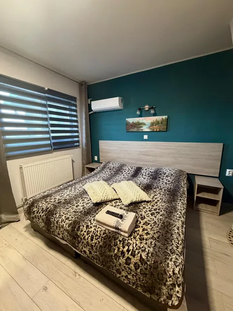 Cameră cu perete verde-petrol și cuvertură leopard
