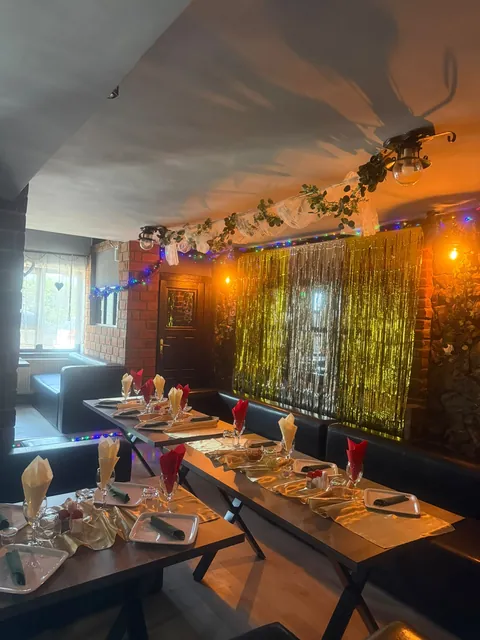 Sala de club cu perdea aurie și mese aranjate