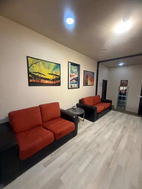 Hol-living cu canapele roșii și tablouri